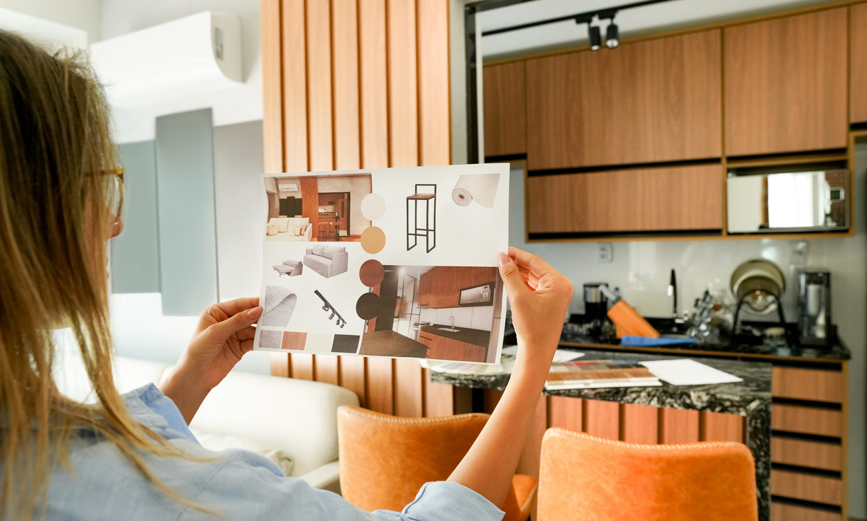 Female architect looking at the picture of interior design